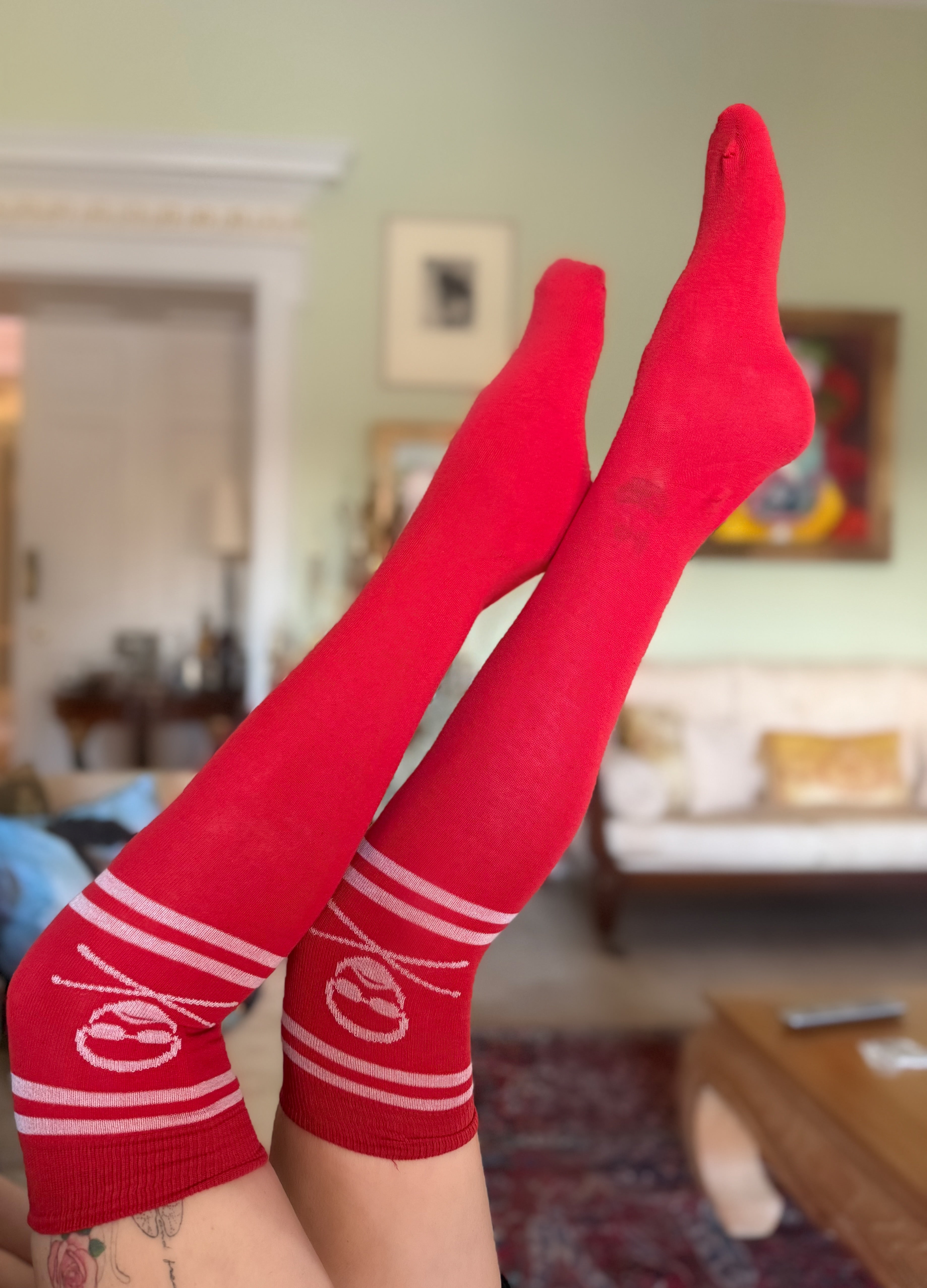 Red knee-high socks with white stripes and skull and crossbones design