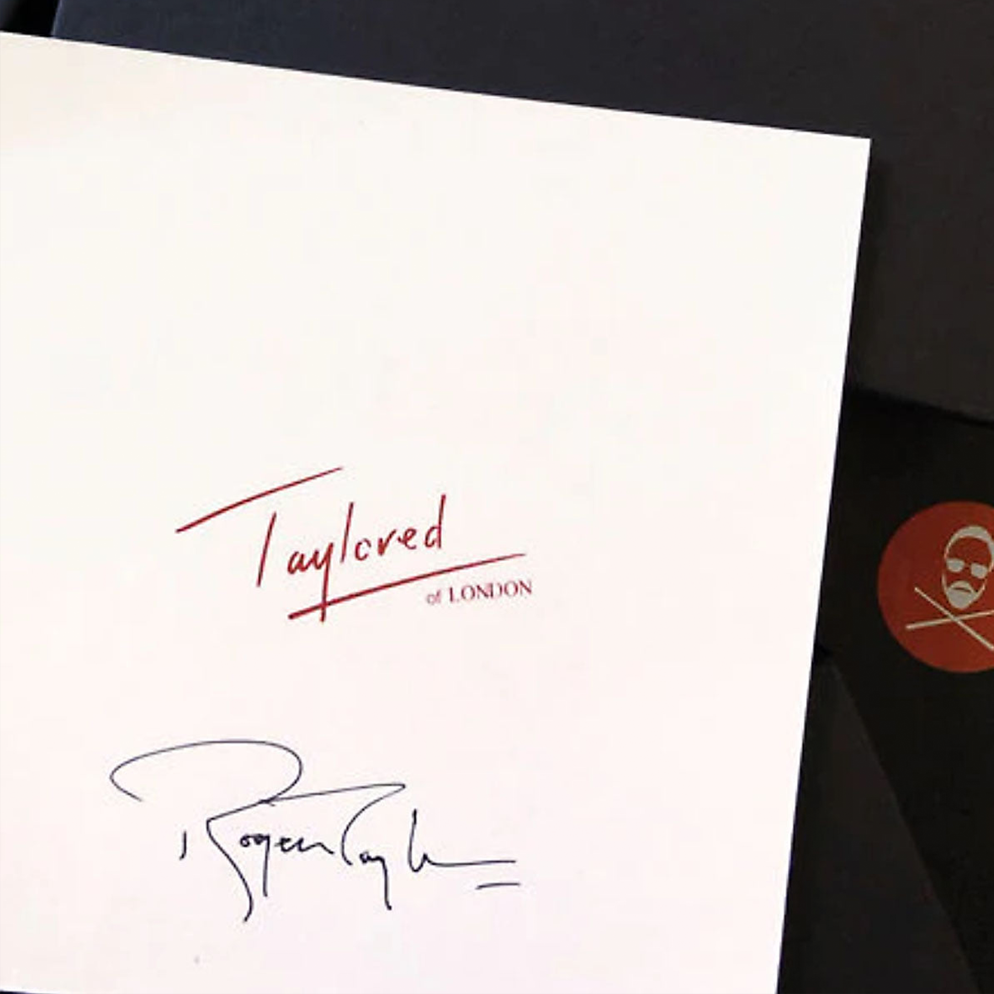 White card with 'Taylored of London' branding and a signature, featuring a red circular logo.